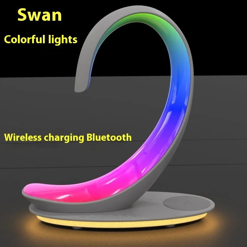 White swan-shaped desk lamp with wireless charging pad and Bluetooth speaker, showing colourful LED lights.