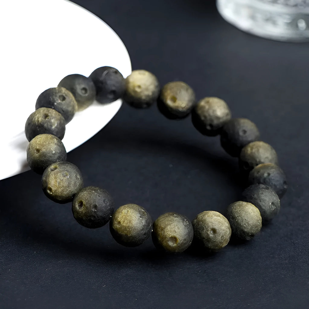 Natural crater ball obsidian bracelet with polished spherical beads showing textured meteorite-style patterns