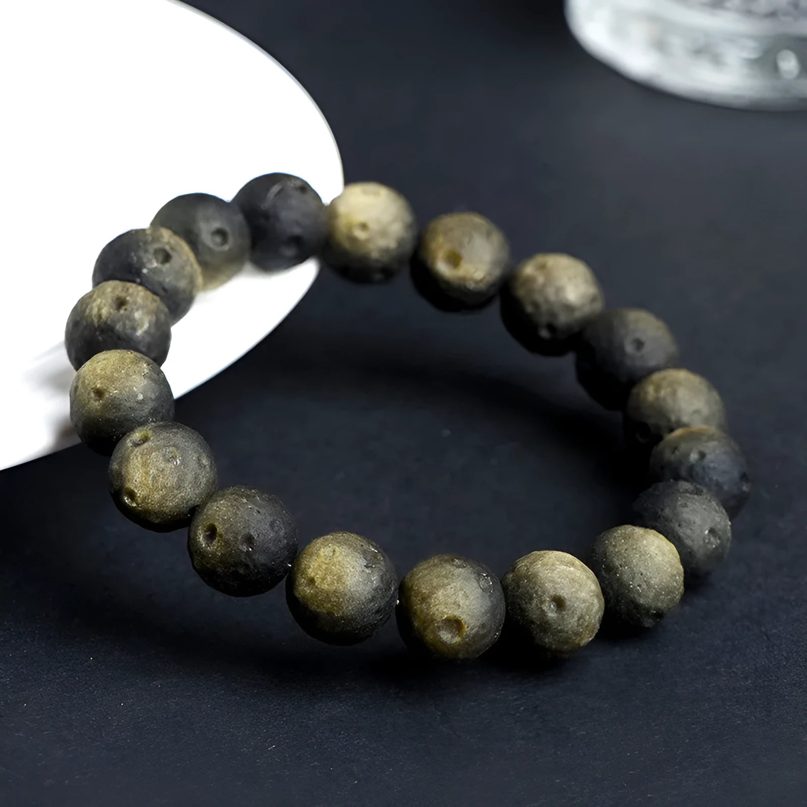 Natural crater ball obsidian bracelet with polished spherical beads showing textured meteorite-style patterns