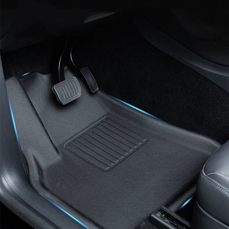 Minimalist black TPR car floor mats designed for Tesla Model Y, showing tailored fit in footwell area.