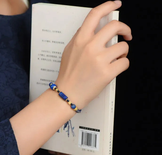 Hand-woven lapis lazuli flexible wire bracelet with simple ethnic design on white background