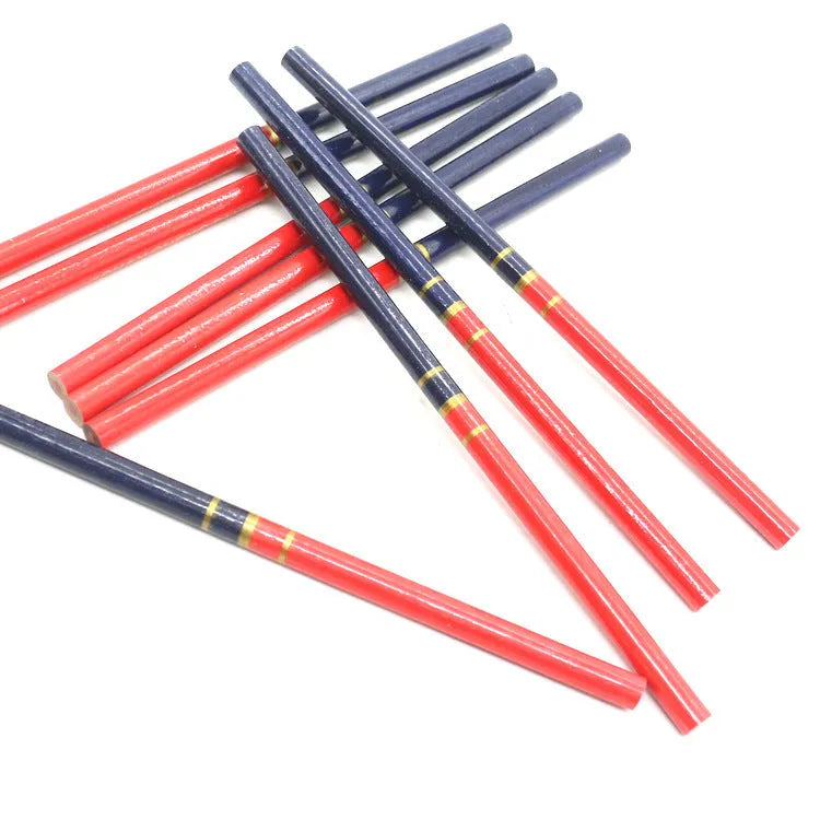 Ten red and blue round wooden carpenter pencils for marking, laid out on a work surface.