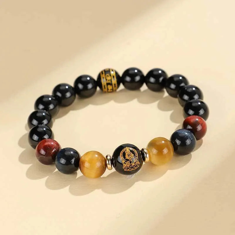 Black agate beaded bracelet with tiger eye stones in ethnic style on plain background