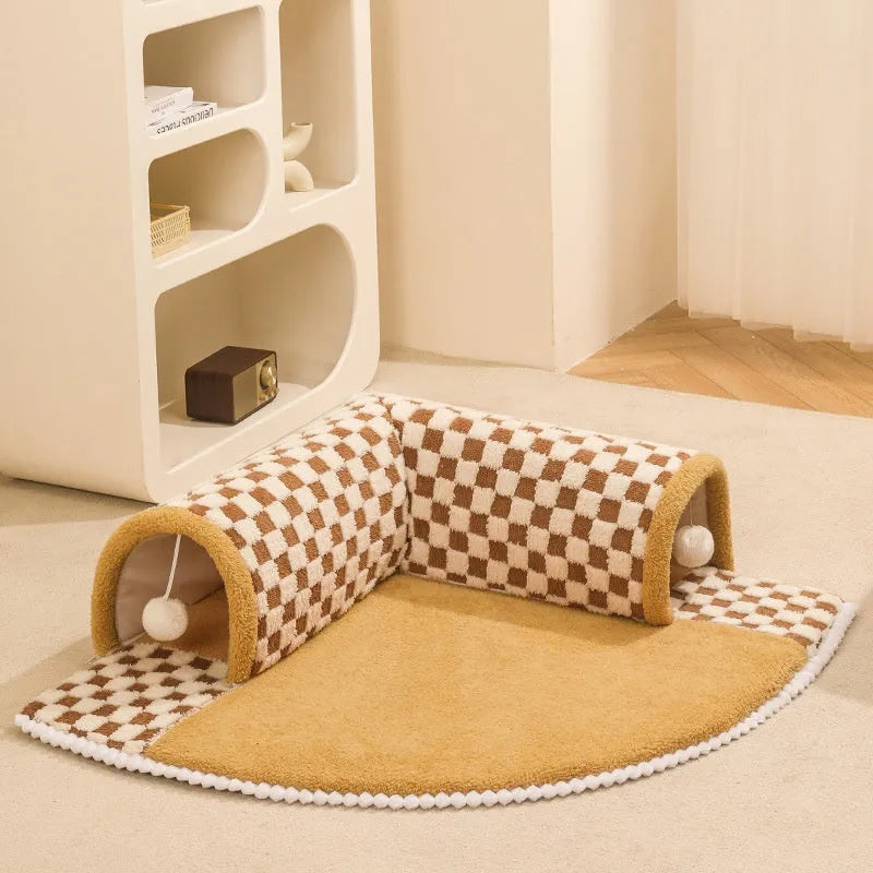 XL brown plaid plush cat tunnel bed with central mat and non-slip bottom on a wooden floor.