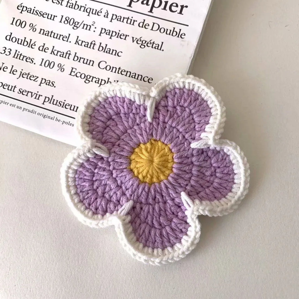 Handmade cotton thread woven flower coaster set of 5 in blue, green, orange, pink, purple on a table