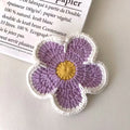 Handmade cotton thread woven flower coaster set of 5 in blue, green, orange, pink, purple on a table