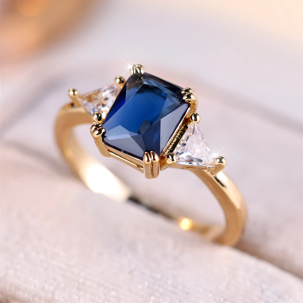 Ladies rectangular copper fashion ring in gold sapphire blue finish on finger