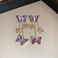 Close-up of women's silver needle blue purple butterfly tassel earrings with crystal flowers on alloy.