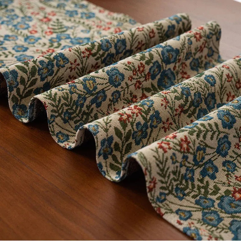 Dark blue striped Nordic style table runner with bouquet tassel decoration laid flat on a table.