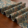 Dark blue striped Nordic style table runner with bouquet tassel decoration laid flat on a table.