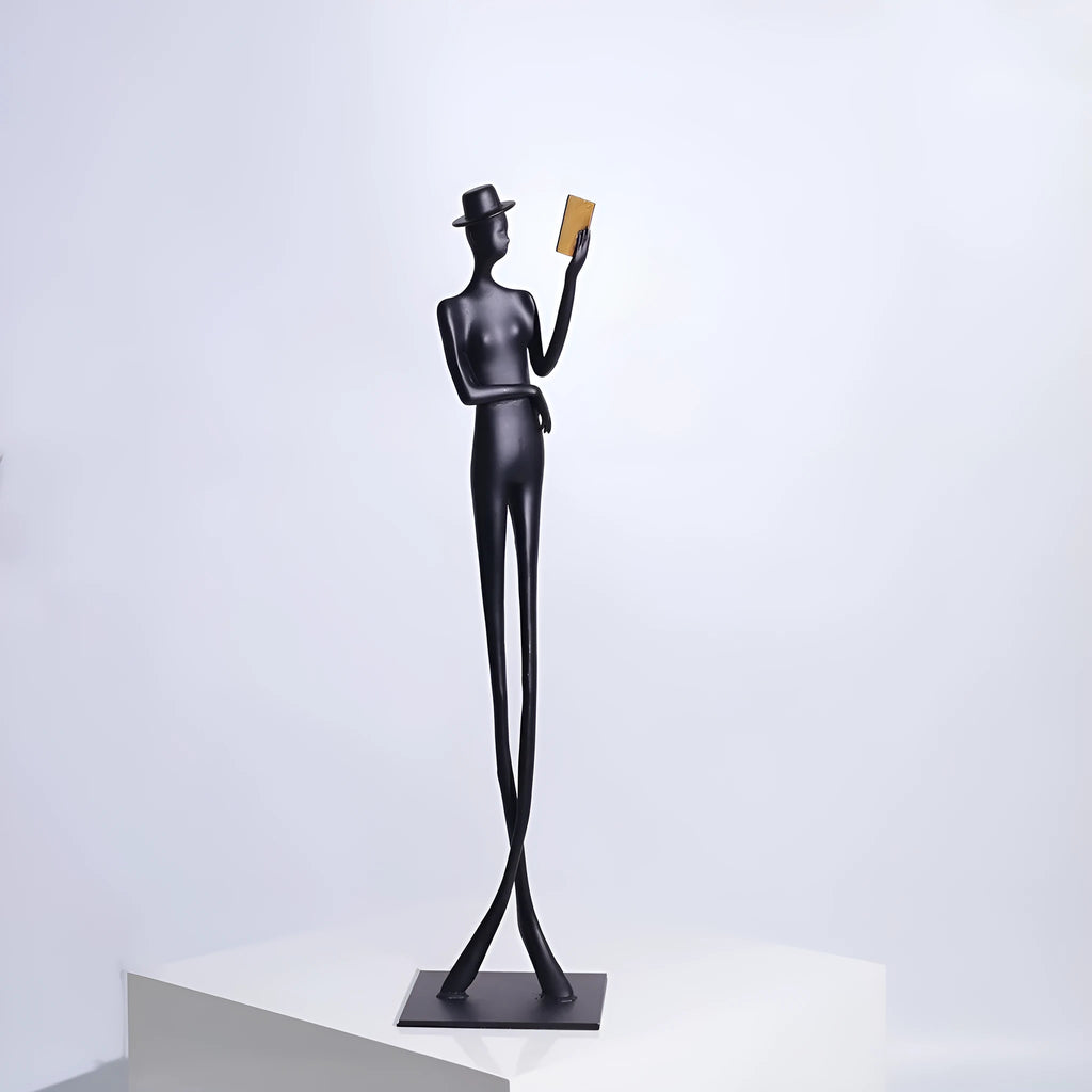 Black cast aluminium reading woman sculpture on desk, modern minimalist design