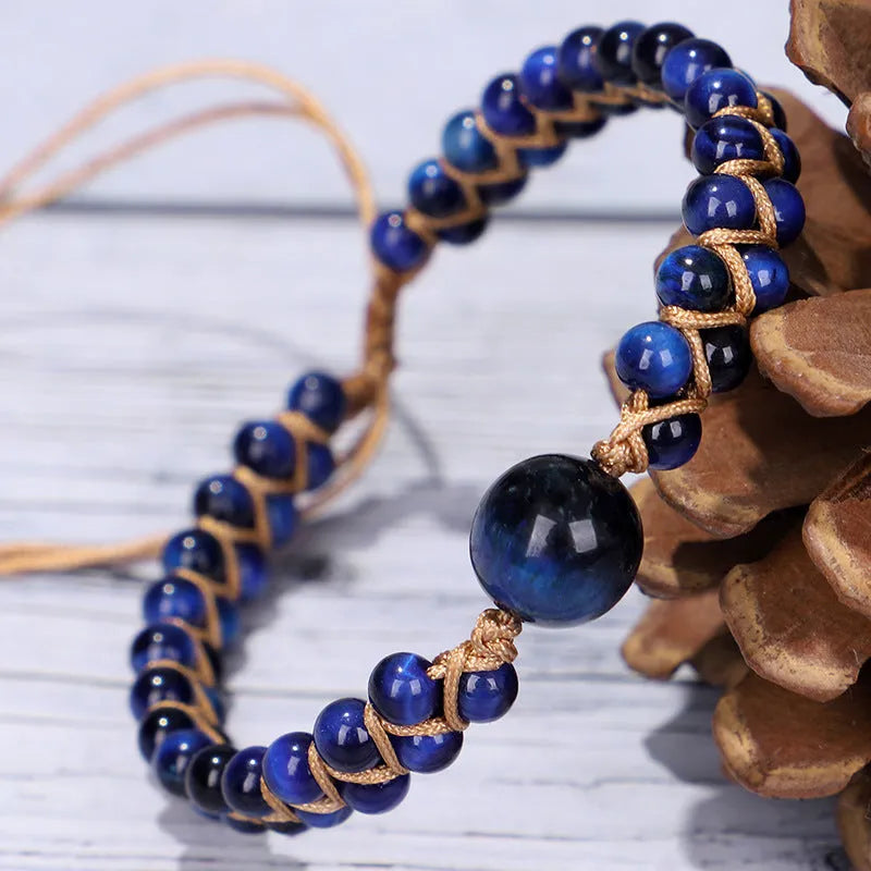 Handmade woven geometric pull bracelet with blue Tigereye stone beads on a wrist.