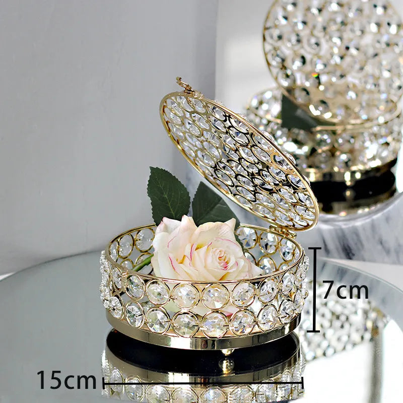 Clear crystal glass jewellery box with a French gold metal frame on a table.