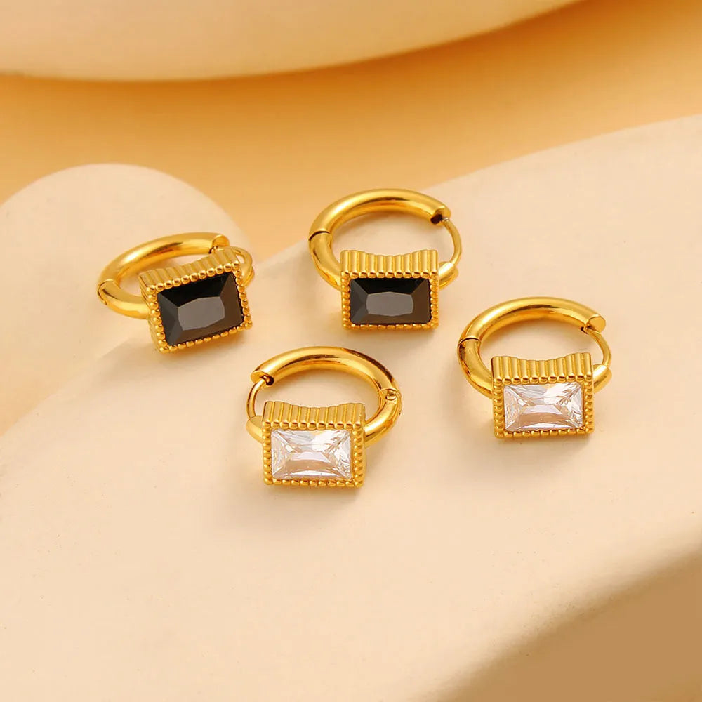 Square stainless steel earrings with round ring design elements in white, black and green colour options