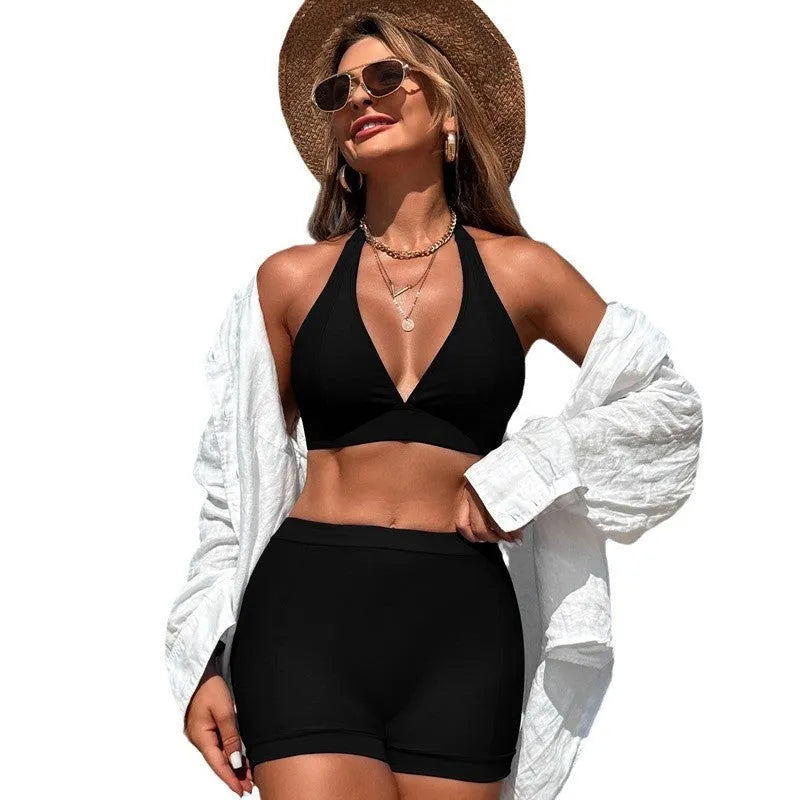 Women's black split bikini swimsuit on a hanger.
