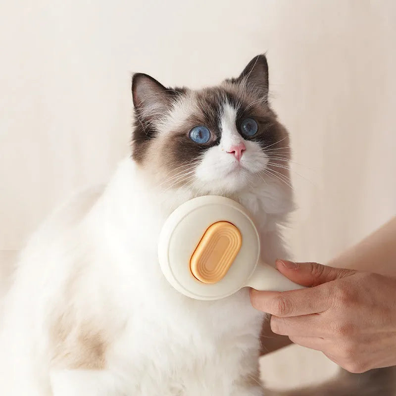 Green and yellow cat grooming brush with stainless steel teeth and a non-slip handle.