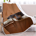 Brown sausage dog themed lamb wool blanket folded on a sofa, 130x150cm size