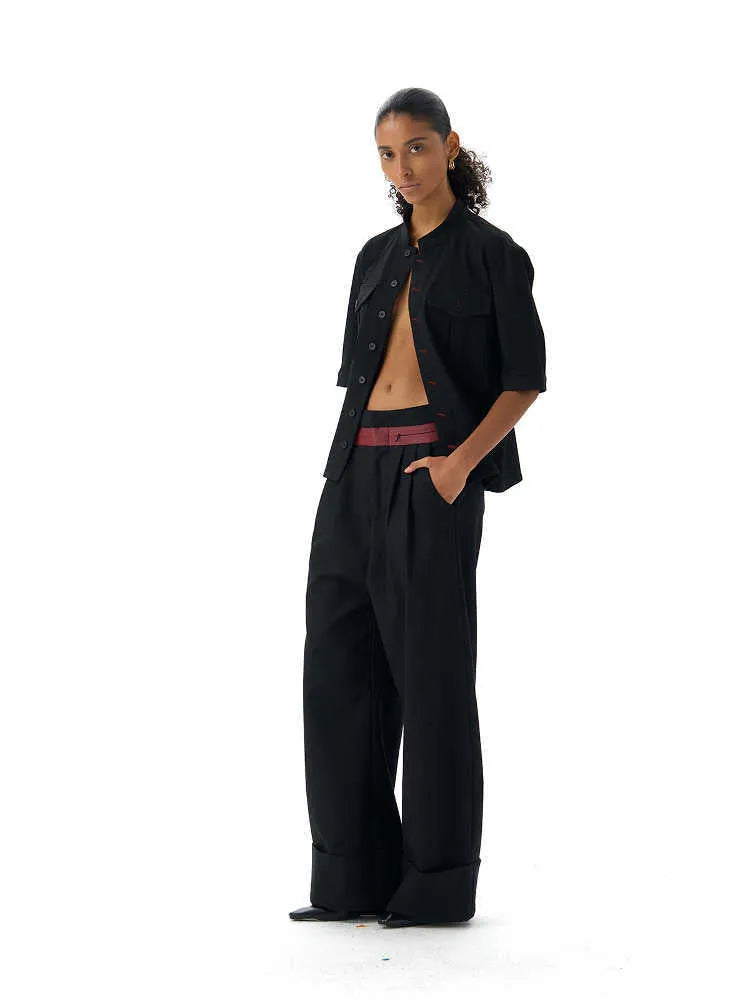 Handmade black loose fit half sleeve hunting shirt with a shirt collar, laid flat.