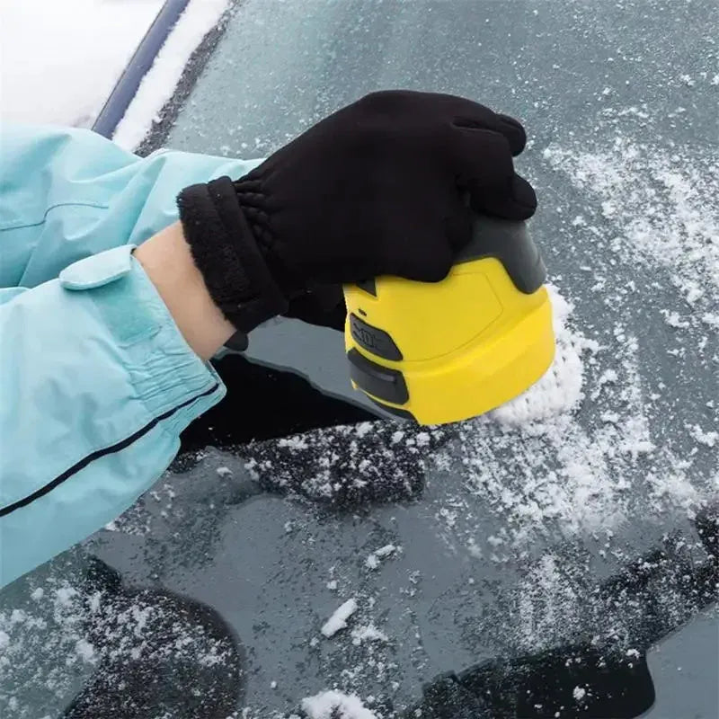 Yellow cordless electric car ice scraper with USB charging cable on a car windshield.