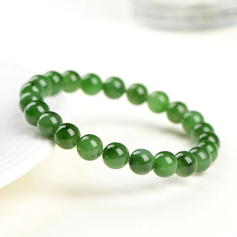 Natural Hetian jade and jasper bead bracelet showing polished spherical beads on a wrist.