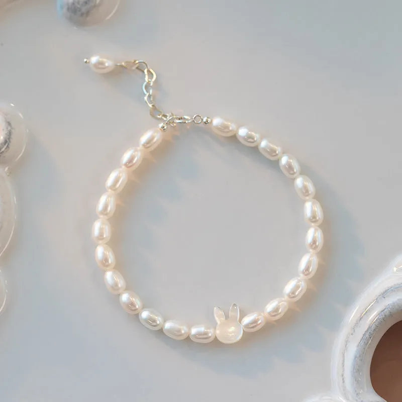 White shell small rice-shaped beads pearl elastic string rabbit bracelet 16cm handmade 925 silver on white background