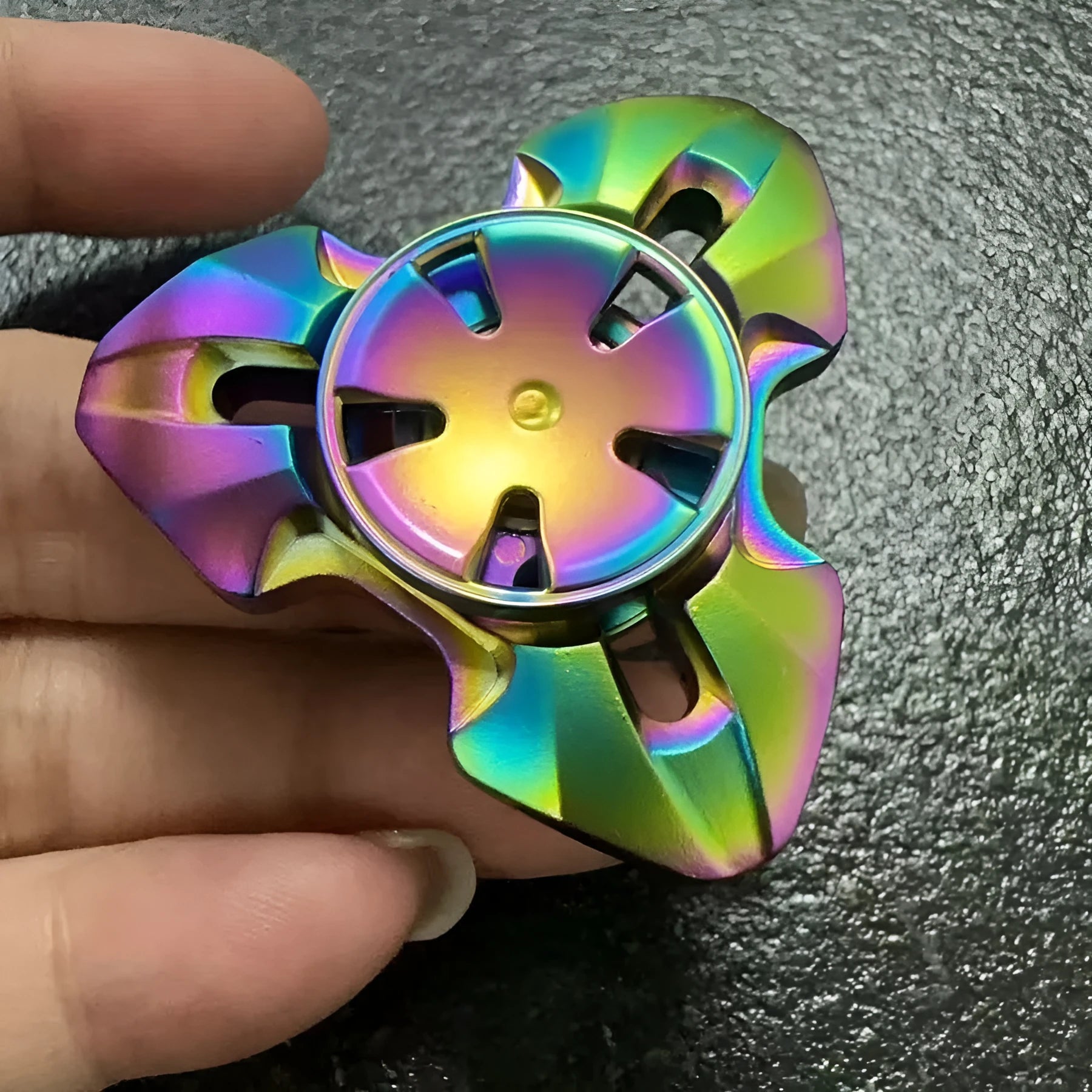Alloy decompression fingertip gyro toy in gun colour finish on a dark background