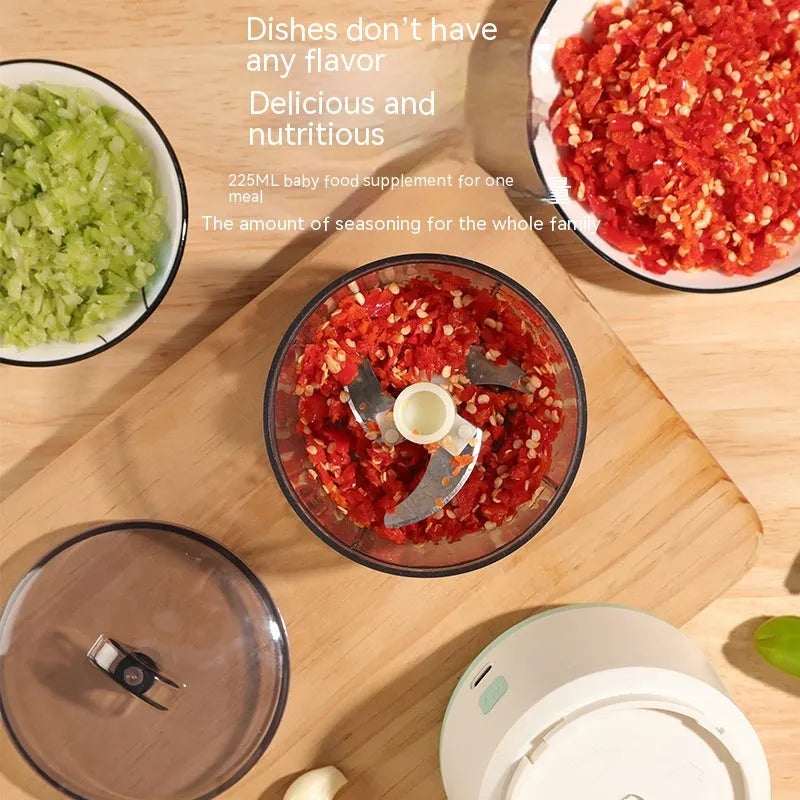 Mini meat grinder with white body, transparent 225ml cup, and anti-slip base on a kitchen countertop