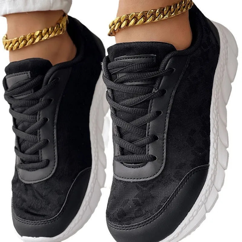 Women's white canvas casual sports shoes with a round toe and flat soft sole on a plain background.