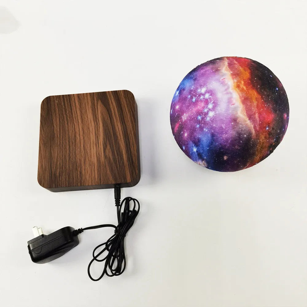 Magnetic levitation galaxy moon lamp floating above walnut-coloured base with starry light projection