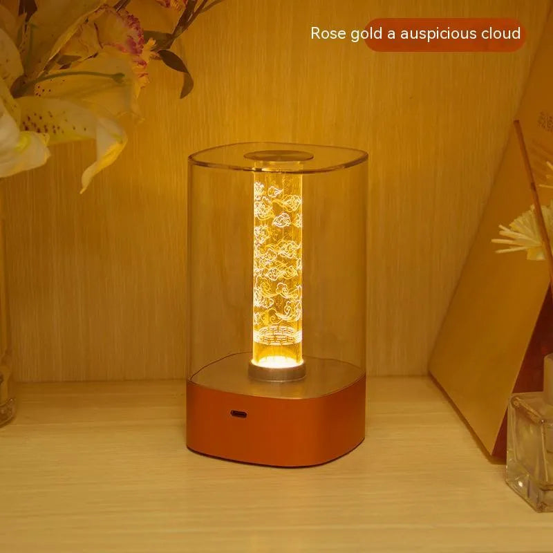 Rose gold LED touch atmosphere light with Auspicious Cloud pattern on a bedside table, USB charging cable included