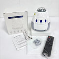 Creative USB space capsule starry atmosphere projection lamp in Space White with remote control on a bedside table