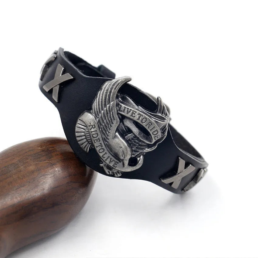 Black leather bracelet with geometric eagle watch-button clasp showing tapered 1.7-3.8cm width