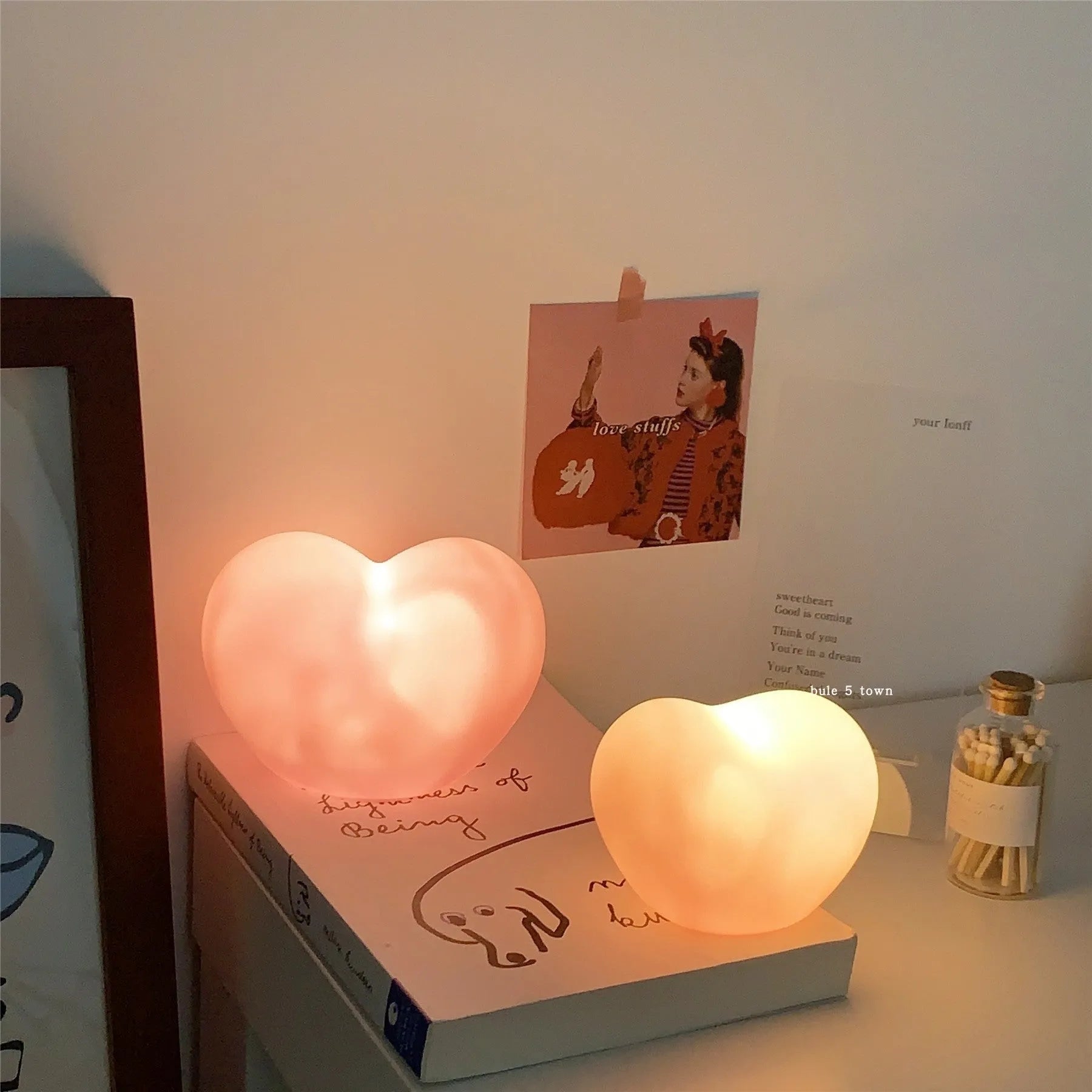 White or pink vinyl love heart atmosphere lamp in small or large size on a table.