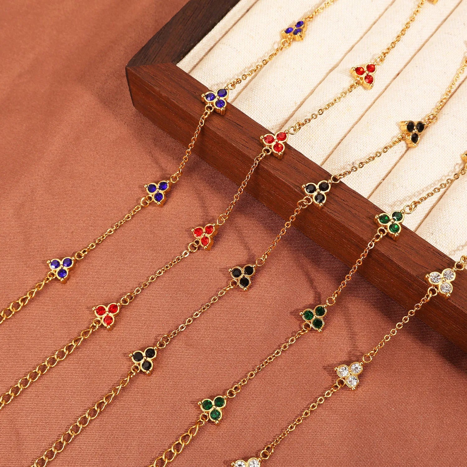 Women's stainless steel bracelet with three triangular diamond charms in geometric design with coloured stones