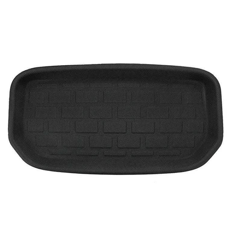 Minimalist black TPR car floor mats designed for Tesla Model Y, showing tailored fit in footwell area.
