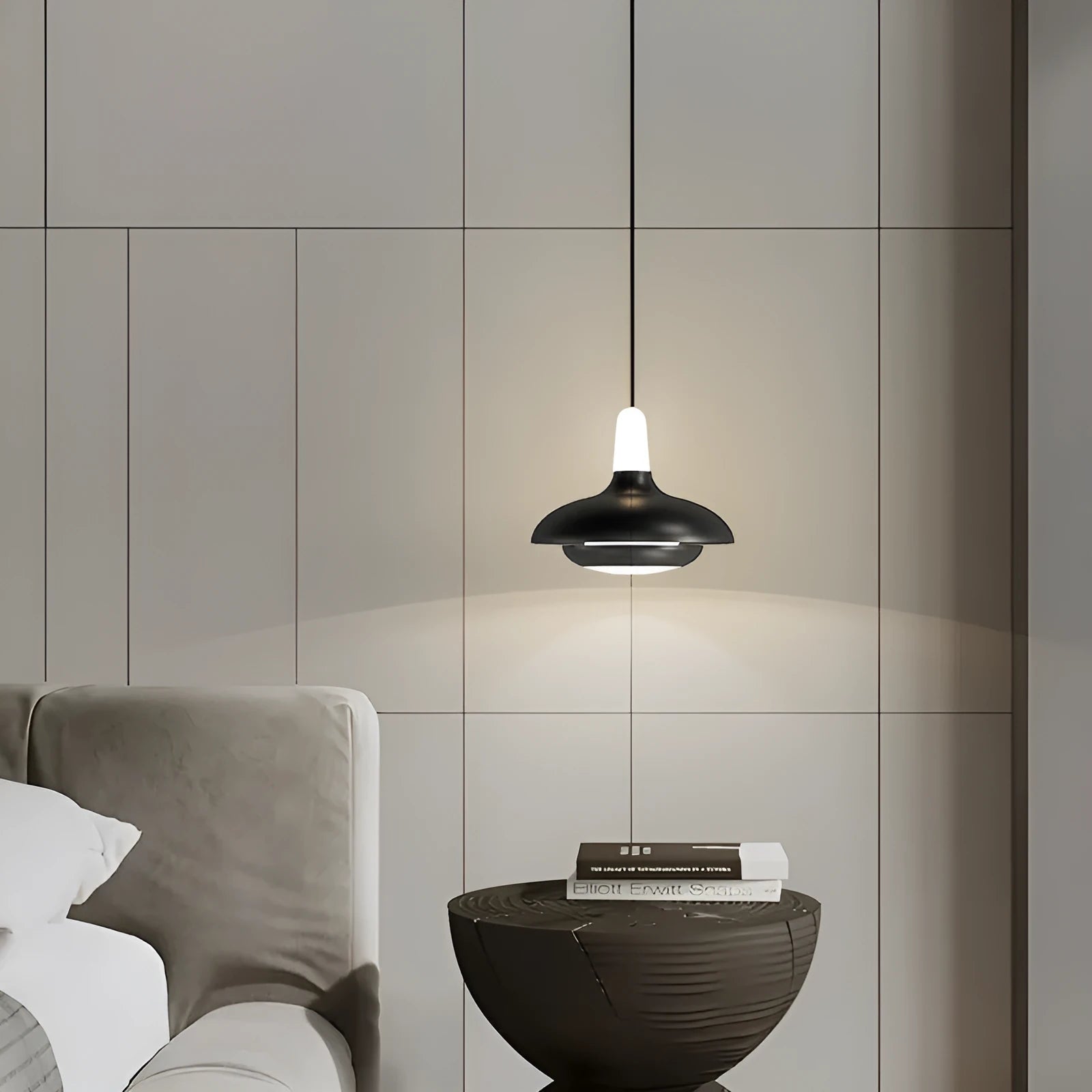 Modern minimalist adjustable bedside pendant light in Moon White shown over a small bedside table