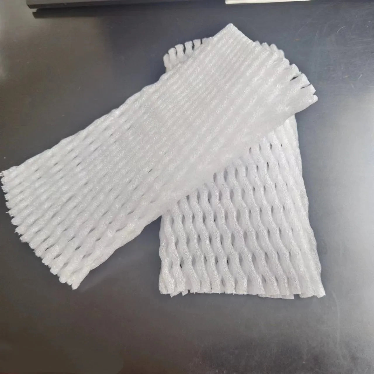 White foam net protective cover for fruit, shown next to an apple, with size options listed.