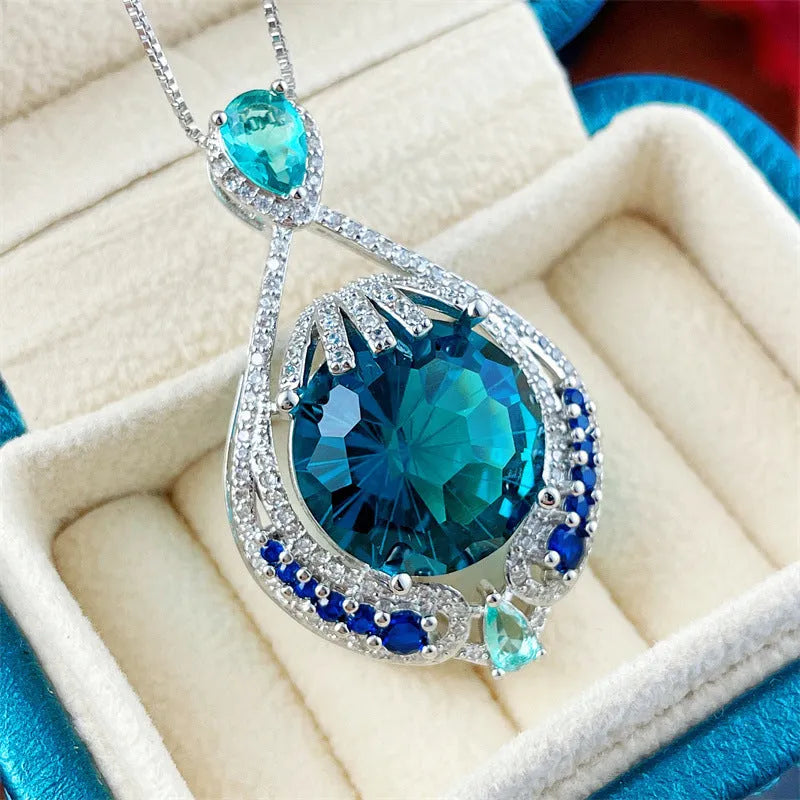 Close-up of a women's geometric necklace with a blue crystal pendant on a water wave chain.