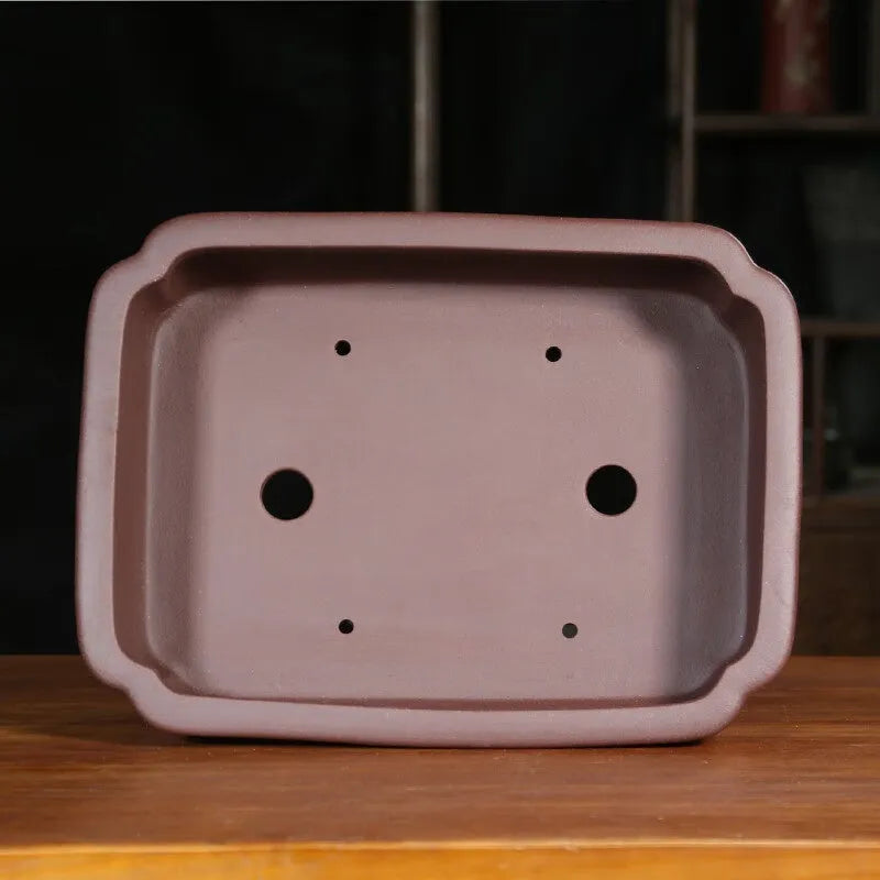 Rectangular antique purple sand bonsai pot on floor, showing Old Segment Mud textured finish.
