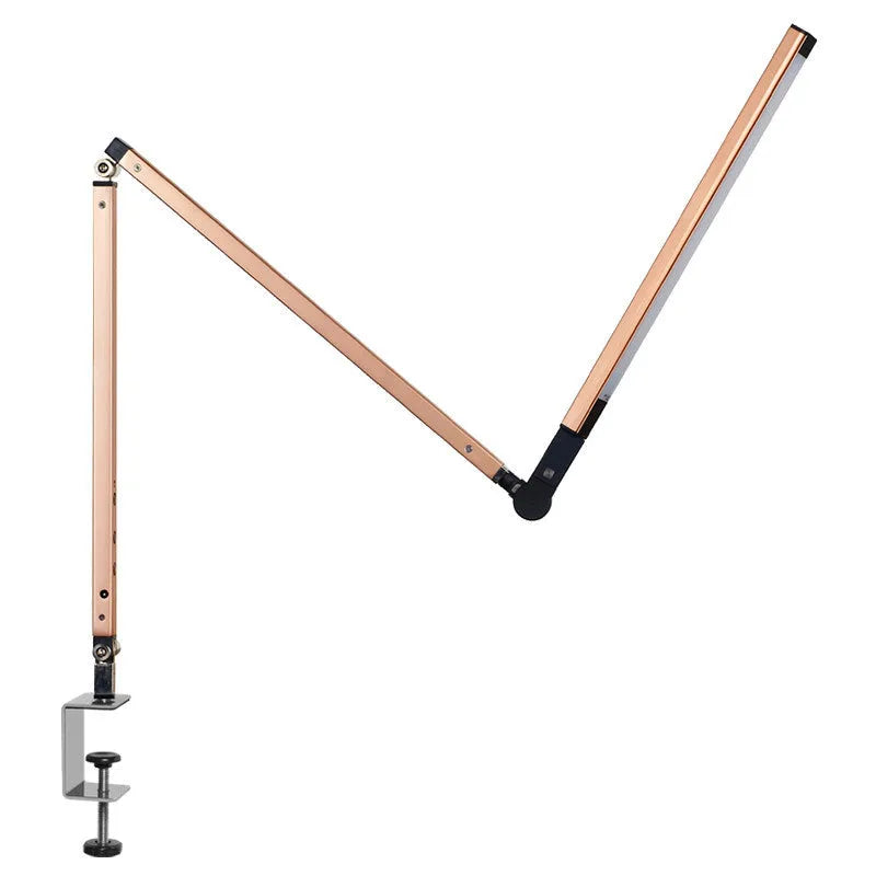 Black clip-on LED desk lamp with remote control attached to a desk edge, showing its folding arm.