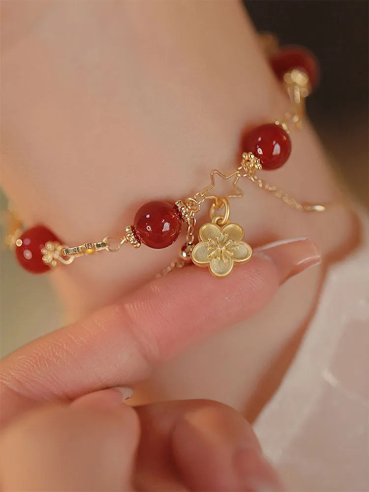 Red agate double layer bracelet with floral and peach blossom charms on adjustable band