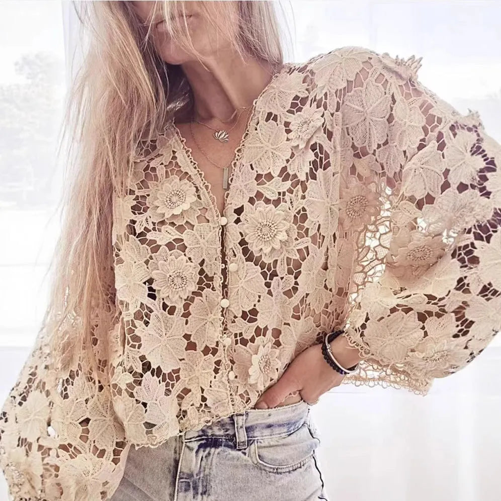 Loose V-neck lace cardigan with white three-dimensional floral decorations on a black background.
