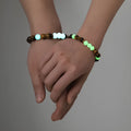 Amber Y552 luminous geometric couple bracelet on dark background showing glow effect