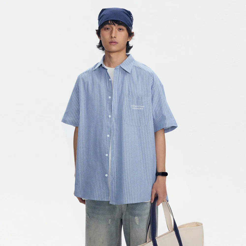 Blue and white striped loose-fit short-sleeved overalls shirt on a hanger