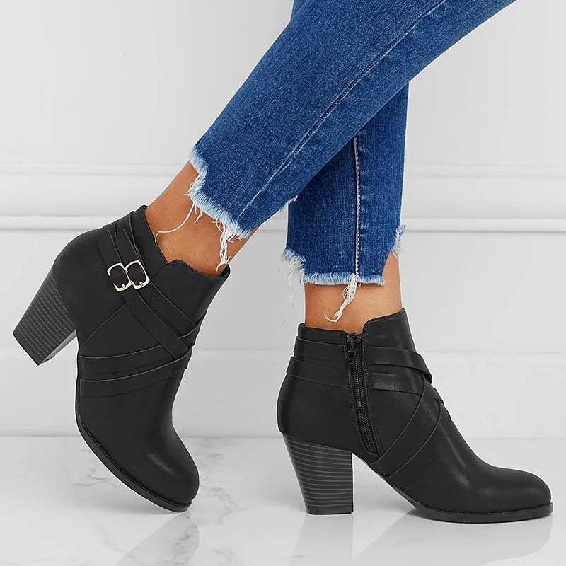 Women's grey short boot with 7cm heel, side zipper, and belt buckle detail on a rubber sole.