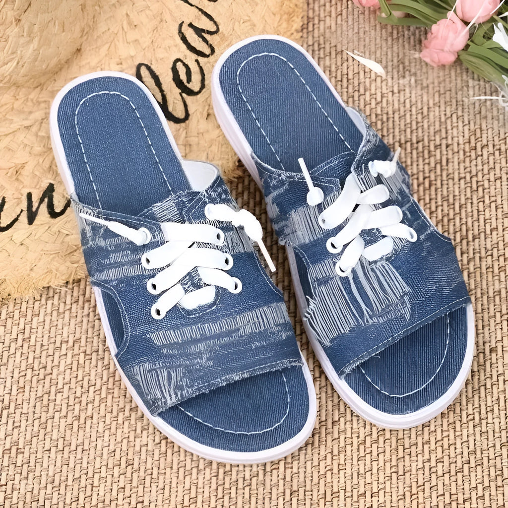 Blue women's Roman style flat canvas slippers with a cloth upper and rubber sole.