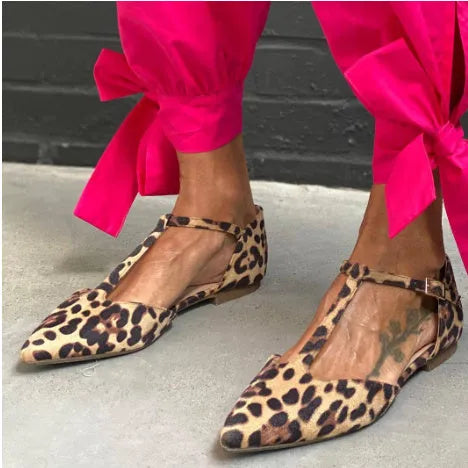 Leopard print women's pumps with pointed toe, low chunky heel, and cross shoulder straps.