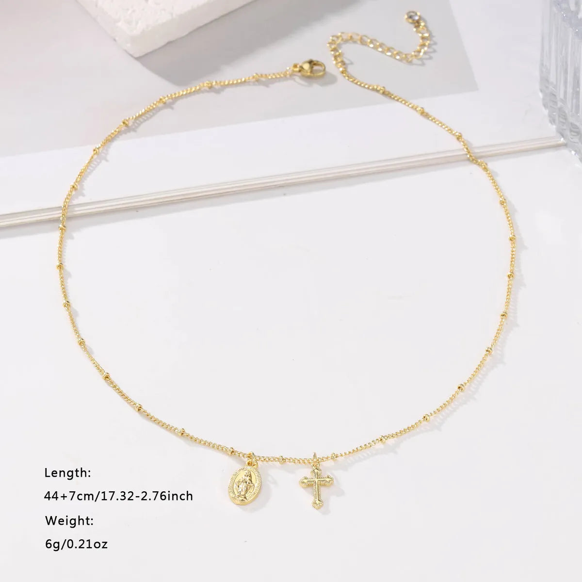 Gold geometric cross Virgin Mary necklace for women on display