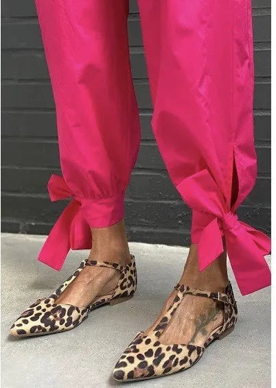 Leopard print women's pumps with pointed toe, low chunky heel, and cross shoulder straps.