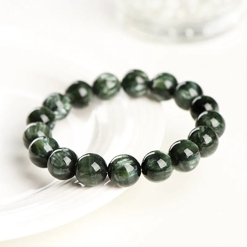 Natural green dragon crystal round bead bracelet with ruyi design on a wrist.